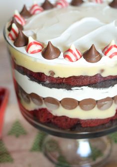 a red velvet cheesecake trifle cake with white frosting and candy canes