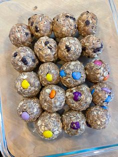 a plastic container filled with lots of chocolate covered balls on top of a wooden table