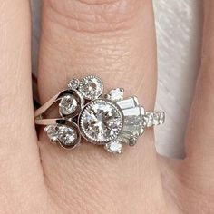 a woman's hand with a diamond ring on top of her finger and an engagement band