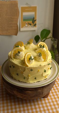 a lemon cake sitting on top of a table next to a plate with slices of lemon