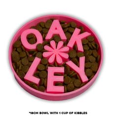 a pink bowl filled with dog food and the words oakley spelled in large letters