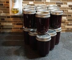 several jars of jam are sitting on the counter