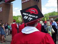 a group of people in graduation caps and gowns are gathered outside the stadium building