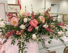 a bouquet of flowers sitting on top of a table next to a white piano in a room