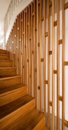 wooden staircase with handrails and white walls