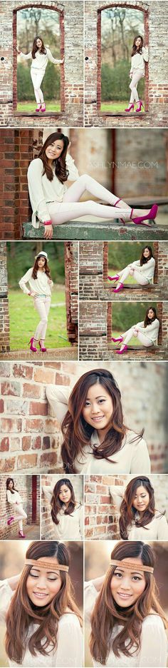 a woman posing in front of a brick wall