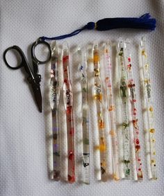 a pair of scissors sitting on top of a table next to some plastic tubes and beads