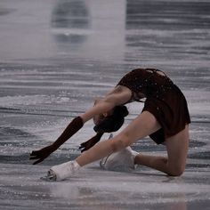 a female figure skating on an ice rink in the middle of it's snowing season