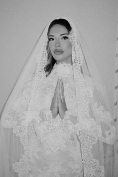 a woman wearing a veil and holding her hands together