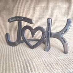 two metal letters that spell out the word love are sitting on top of a bed