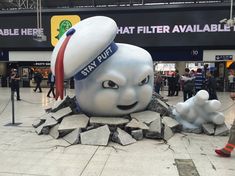 there is a giant snowman statue in the middle of an airport lobby with people walking around