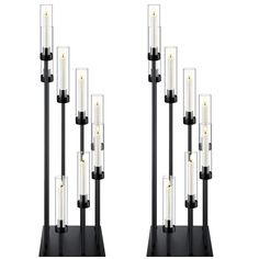 a pair of black and clear candles are on a stand with two white candles in the middle