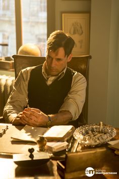 a man sitting at a table with an open book