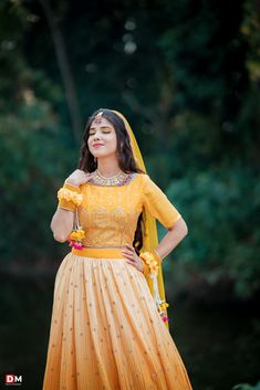 a woman in a yellow dress posing for a photo with her hands on her hips