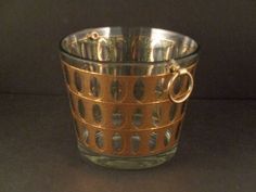 a gold colored glass cup sitting on top of a table