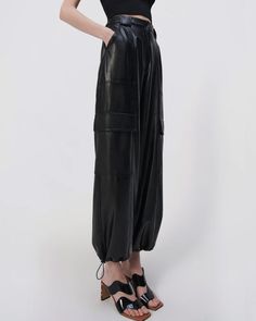 SIMKHAI Black Luxe Vegan Leather Cargo Pant Mid rise Button closure Zip fly Belt loops Side slip pockets Back patch pockets Cargo flap pockets at leg Wide through leg Drawcord ankle cuffs Ankle length Vegan leather fabrication Lined 100% polyurethane outer, 100% viscose lining Evening Jumpsuit, Women Men Shoes, Ankle Cuffs, Casual Blazer, Cargo Pant, Back Patch, Beauty Gift, Vest Dress, Flap Pocket