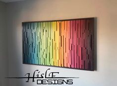 a rainbow colored painting hanging on the side of a wall