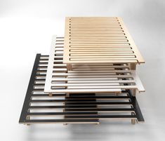 a wooden table with black and white strips on it's sides, sitting on a gray surface