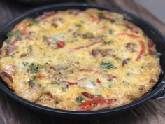 an omelet in a black pan on a wooden table