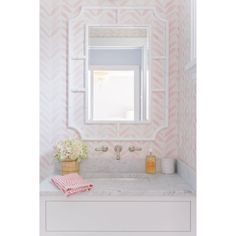 a white sink sitting under a mirror next to a wall mounted faucet in a bathroom