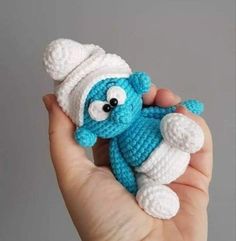 a crocheted blue and white teddy bear with a hat on it's head