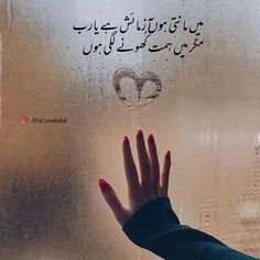 a woman's hand on the window with rain drops and words written in arabic