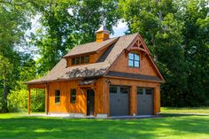 a two car garage in the middle of a grassy area with trees and grass around it