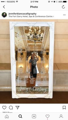 a woman standing in front of a large mirror