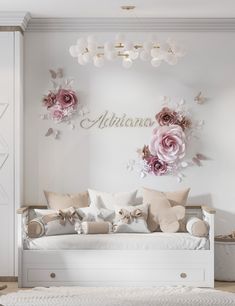 a living room with white furniture and pink flowers on the wall above it is a day bed