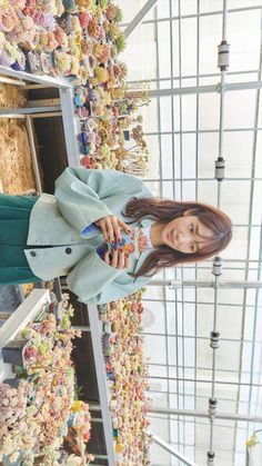 a woman standing in front of a display of flowers