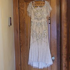 a white dress hanging on a wooden door