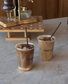 two iced coffees sitting on top of a table