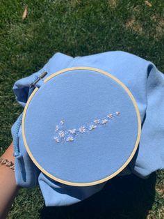 someone is stitching the word joy on a blue cloth in front of their hand