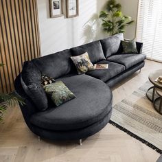 a large blue couch sitting in a living room next to a coffee table and potted plant