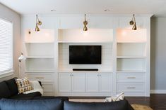 a living room filled with furniture and a flat screen tv on top of a wall