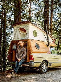 a man sitting in the back of a truck with a camper on it's bed