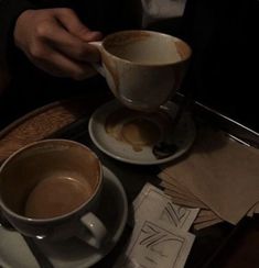 two cups of coffee sitting on top of a table