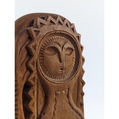 a carved wooden statue with a woman's face