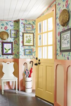 an entryway with colorful wallpaper and pictures on the walls