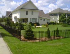 a black fence in front of a white house