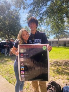 a man standing next to a woman holding a sign