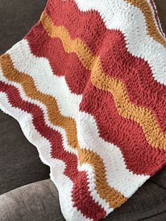 a crocheted blanket sitting on top of a couch