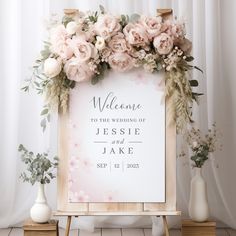 a welcome sign with pink flowers and greenery