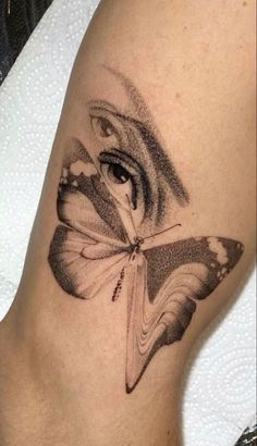 a woman's leg with a butterfly tattoo on the lower half of her leg