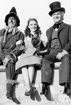 three people dressed in costumes sitting on a bench