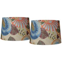 a pair of lamps that are sitting next to each other on a white background with blue, orange and green flowers