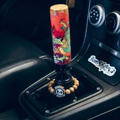 the inside of a car with a steering wheel knob and a dragon design on it