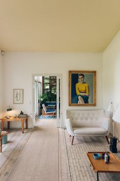 a living room filled with furniture and a painting on the wall