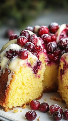 a white plate topped with a cake covered in frosting and cranberries