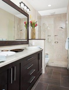 a bathroom with two sinks and a large mirror on the wall next to the shower